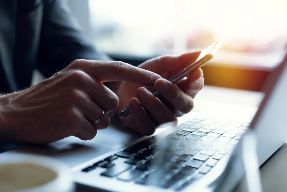 des mains en train d'envoyer un SMS sur un téléphone portable