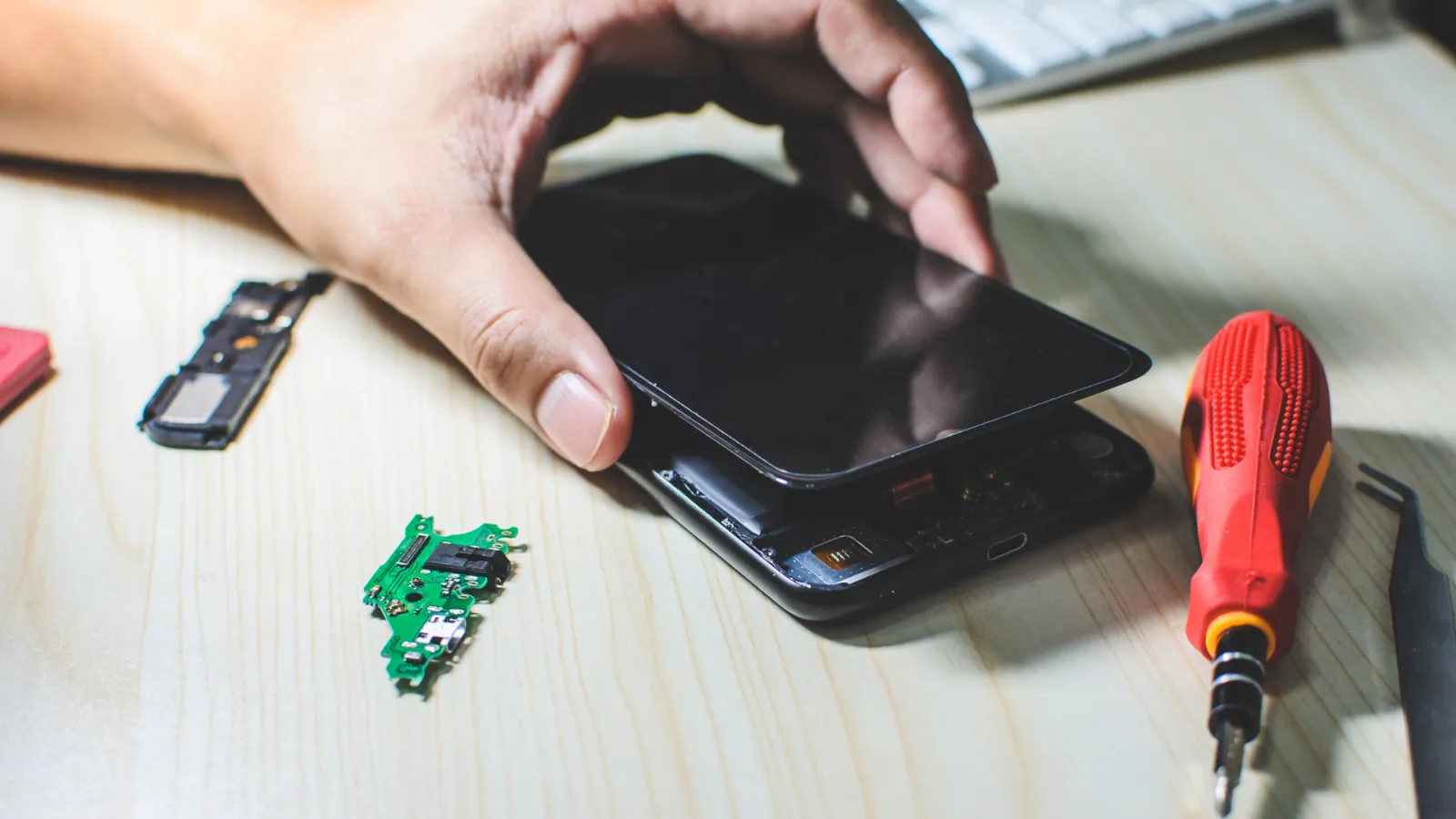 téléphone portable dont le dos est ouvert et un tournevis