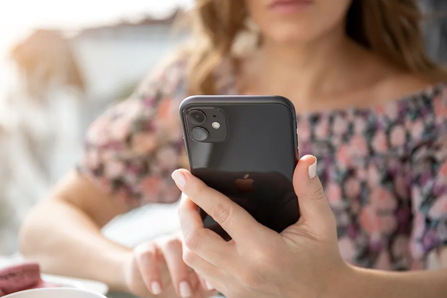 Une femme tenant un iPhone 11