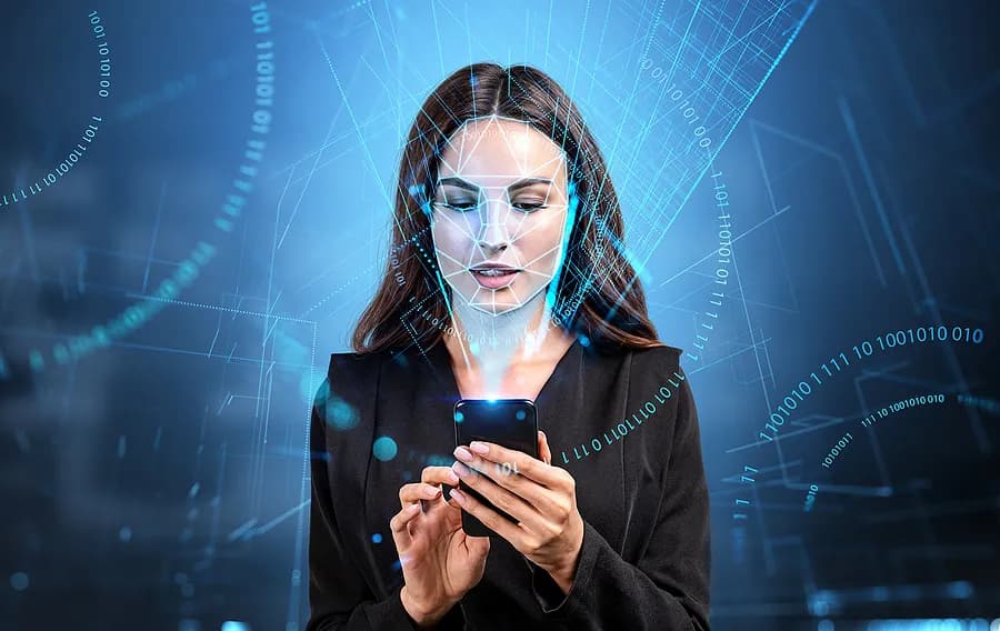 Une femme tenant son téléphone portable sur un fond bleu.