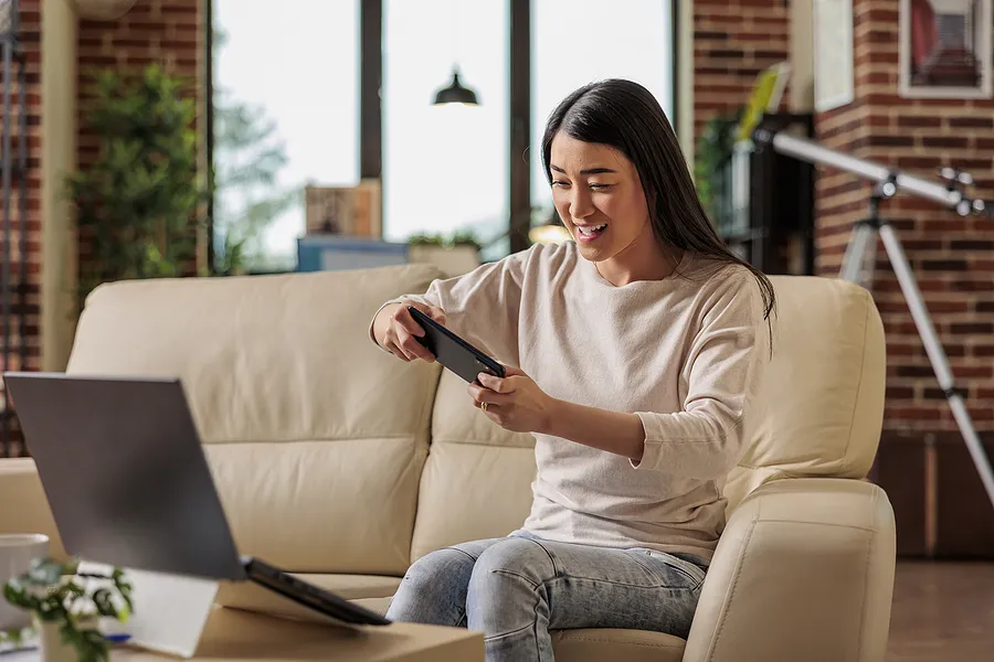 Une femme jouant à des jeux sur son téléphone portable.