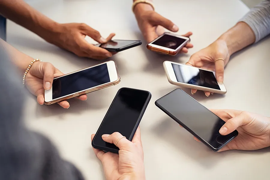 Des mains tenant des appareils mobiles.