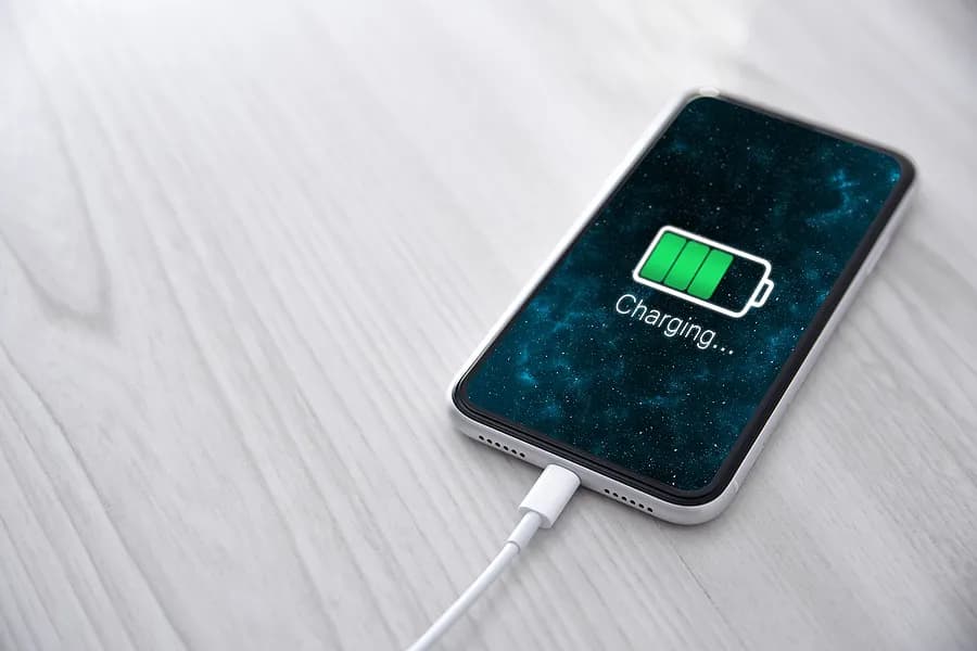 Téléphone portable branché sur son chargeur.