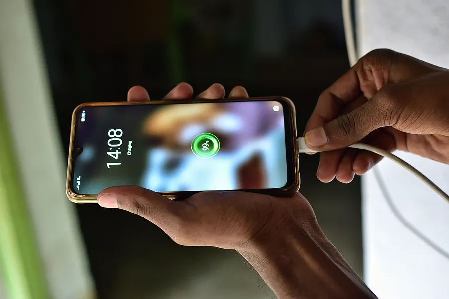 une personne branchant un smartphone sur un chargeur