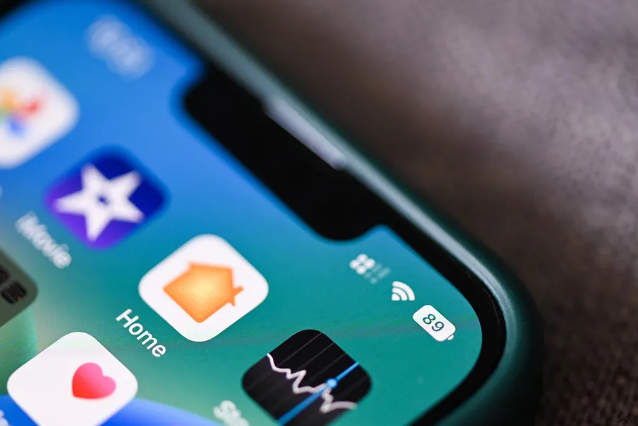 Gros plan sur l'écran d'un iPhone affichant des icônes d'applications et un indicateur de batterie à 89 %, mettant en évidence l'état de la batterie.