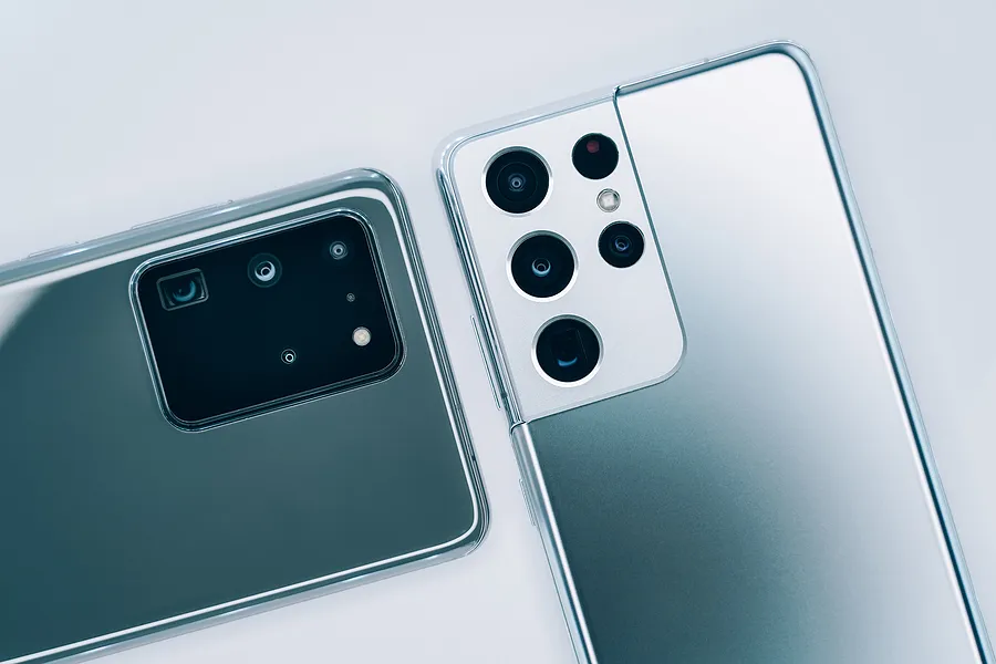 Deux smartphones Samsung Galaxy posés face vers le bas, mettant en évidence les modules de caméra arrière et les différences de design lors du passage à un nouveau modèle Galaxy en 2026.